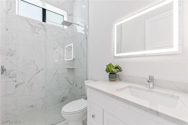 bathroom featuring vanity, toilet, and a tile shower