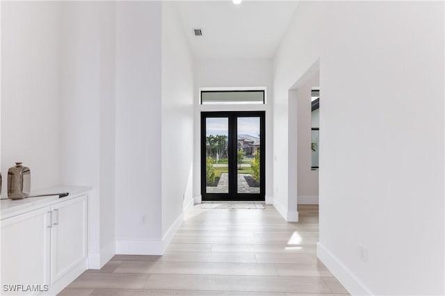 interior space with french doors and light wood-type flooring