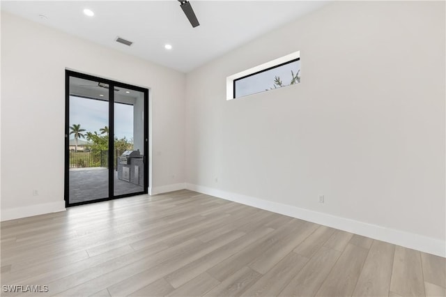 empty room with ceiling fan and light hardwood / wood-style floors