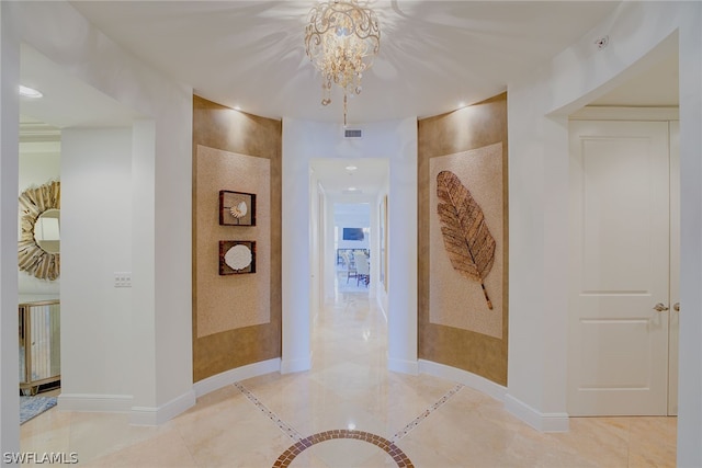 hallway featuring tile patterned floors and a chandelier