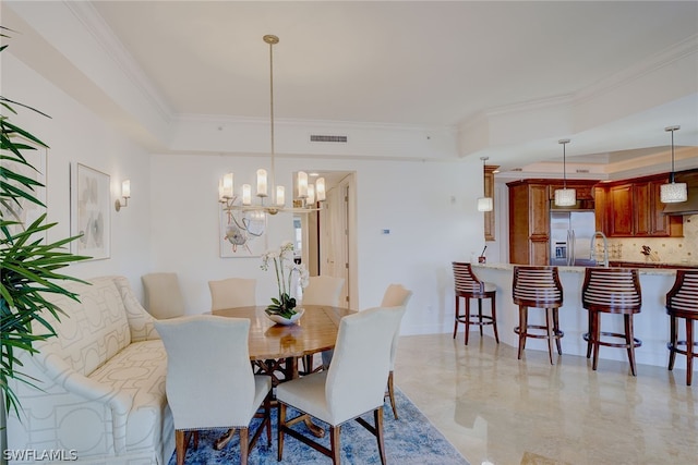 tiled dining room featuring sink, a chandelier, and ornamental molding