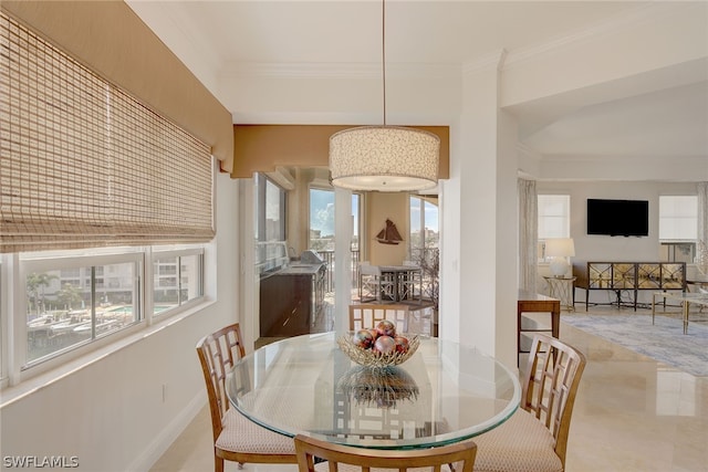 dining area with tile patterned floors, a wealth of natural light, and ornamental molding