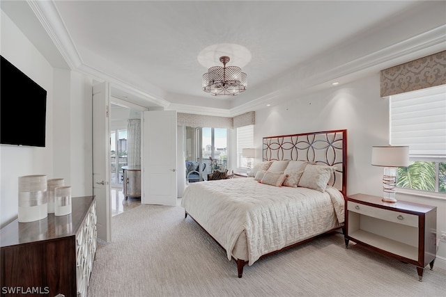 carpeted bedroom with multiple windows, a tray ceiling, a notable chandelier, and ornamental molding