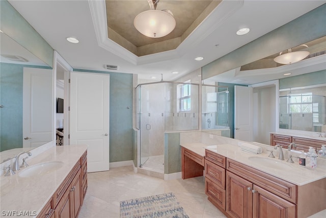 bathroom featuring a shower with shower door, vanity, a tray ceiling, and tile patterned floors