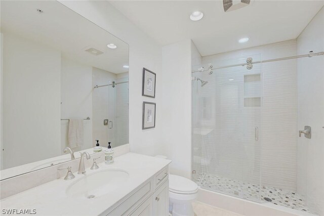 bathroom with vanity, an enclosed shower, and toilet