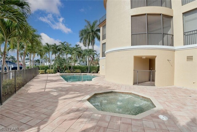 view of pool with a community hot tub and a patio