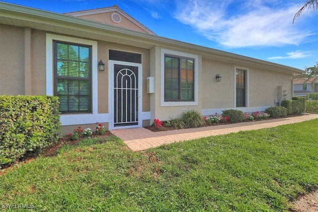 7685 Meadow Lakes Dr Unit 1301, Naples, FL 34104 - doorway to property featuring stucco siding and a yard