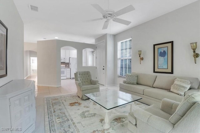 7685 Meadow Lakes Dr Unit 1301, Naples, FL 34104 - living room featuring arched walkways, a ceiling fan, light tile patterned floors, and baseboards