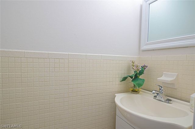 bathroom with vanity, decorative backsplash, and tile walls