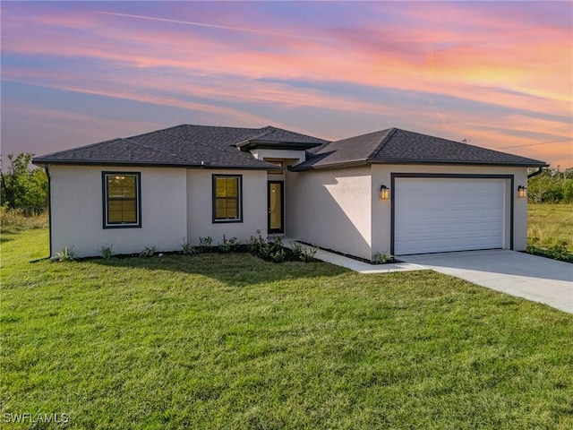 view of front facade with driveway, stucco siding, an attached garage, and a front yard