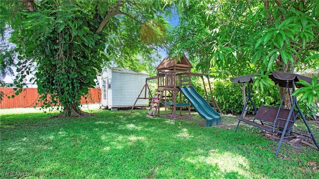 view of playground featuring a lawn and a shed