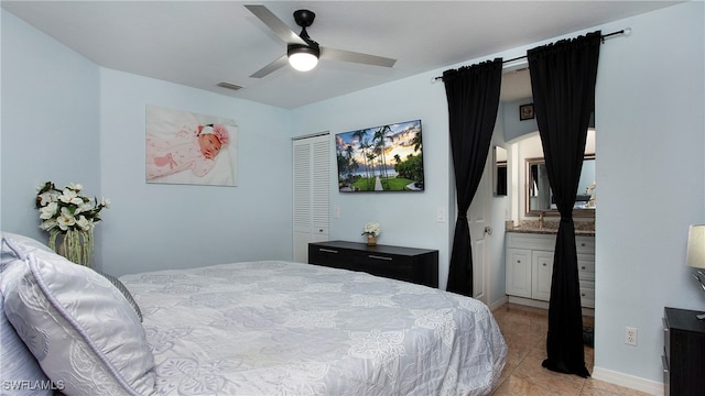 bedroom with a closet, ceiling fan, light tile patterned flooring, and ensuite bath