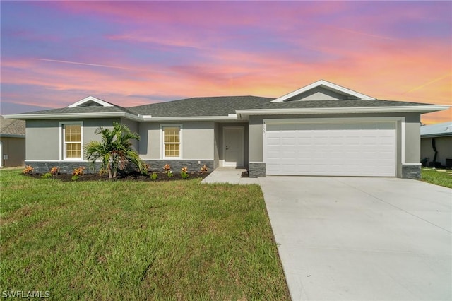 single story home featuring a garage, concrete driveway, a lawn, stone siding, and stucco siding