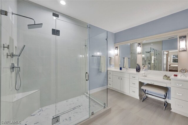 bathroom with vanity and a shower with door