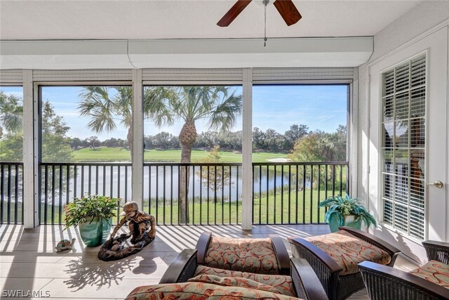 sunroom with a water view, a wealth of natural light, and ceiling fan