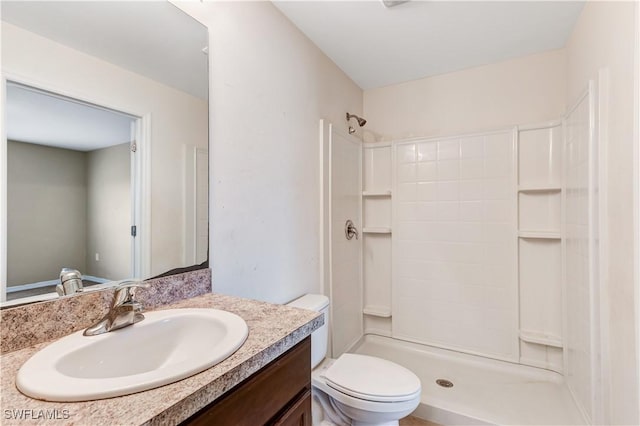 bathroom featuring vanity, a shower, and toilet