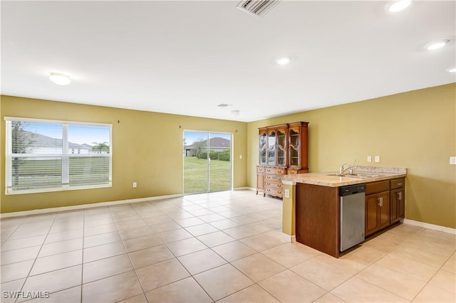 kitchen with sink, light tile patterned floors, dishwasher, a wealth of natural light, and kitchen peninsula