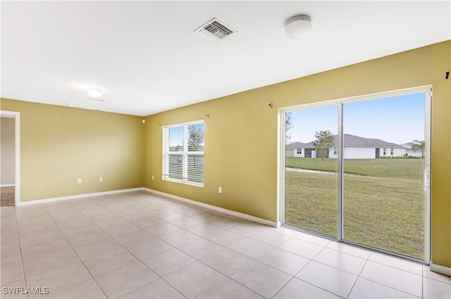 tiled empty room featuring plenty of natural light