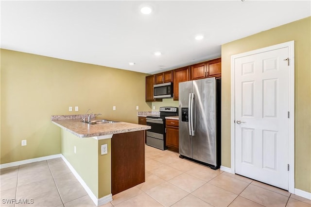 kitchen featuring stainless steel appliances, kitchen peninsula, sink, and light tile patterned floors