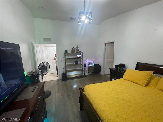 bedroom with dark hardwood / wood-style floors and high vaulted ceiling