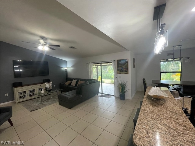 tiled living room with ceiling fan and lofted ceiling