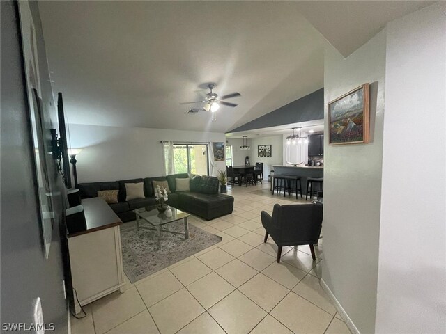 living room with ceiling fan, lofted ceiling, and light tile patterned floors