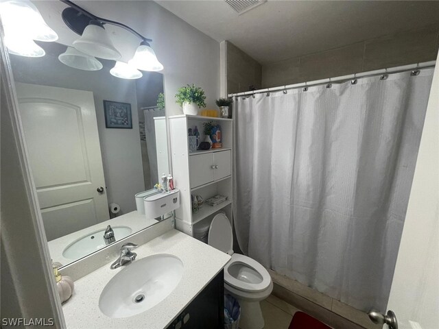 bathroom with vanity, curtained shower, and toilet