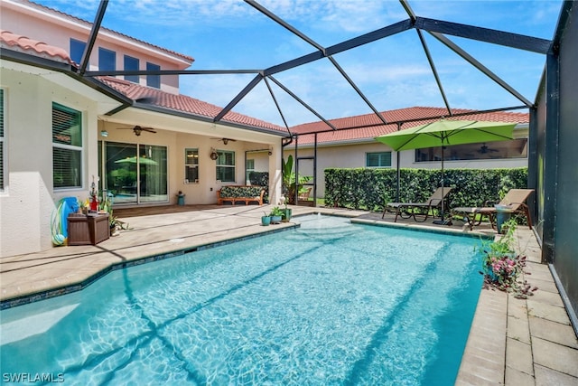 view of swimming pool with a lanai, ceiling fan, and a patio