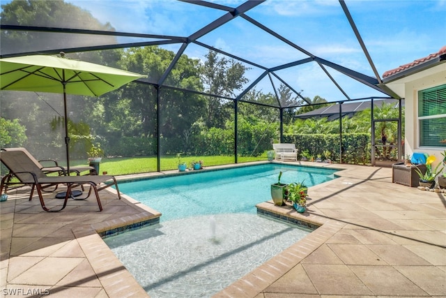 view of pool with glass enclosure and a patio area