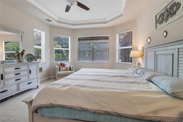 carpeted bedroom featuring ceiling fan, ornamental molding, and a raised ceiling