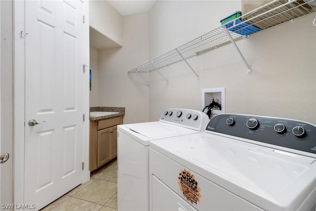 washroom featuring light tile patterned floors, cabinets, and washer and dryer