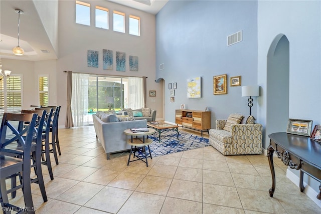 tiled living room with a high ceiling and a healthy amount of sunlight