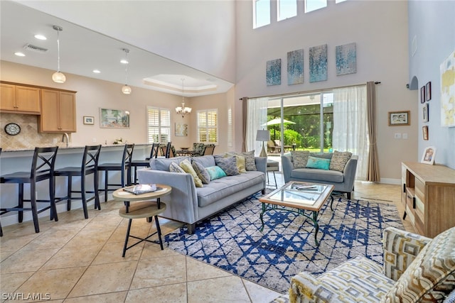 living room featuring a notable chandelier, light tile patterned flooring, and a high ceiling