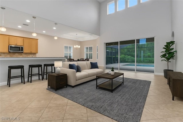 7787 Martino Cir, Naples, FL 34112 - living area featuring light tile patterned flooring, a high ceiling, recessed lighting, and a chandelier