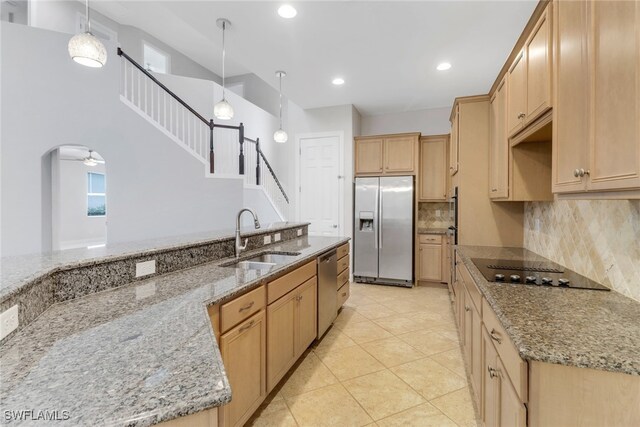 7787 Martino Cir, Naples, FL 34112 - kitchen featuring appliances with stainless steel finishes, light brown cabinets, decorative backsplash, light stone countertops, and recessed lighting