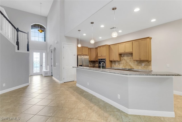 7787 Martino Cir, Naples, FL 34112 - kitchen featuring appliances with stainless steel finishes, decorative backsplash, light stone countertops, light tile patterned floors, and recessed lighting