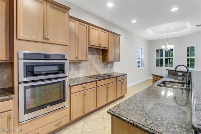7787 Martino Cir, Naples, FL 34112 - kitchen featuring stainless steel double oven, black electric stovetop, decorative backsplash, recessed lighting, and dark stone countertops