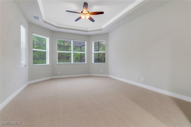 7787 Martino Cir, Naples, FL 34112 - spare room featuring a raised ceiling, light carpet, plenty of natural light, and a ceiling fan