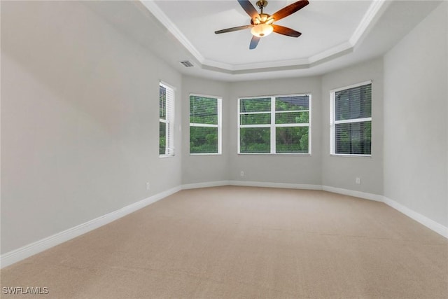 7787 Martino Cir, Naples, FL 34112 - spare room featuring a tray ceiling, light colored carpet, crown molding, and a ceiling fan