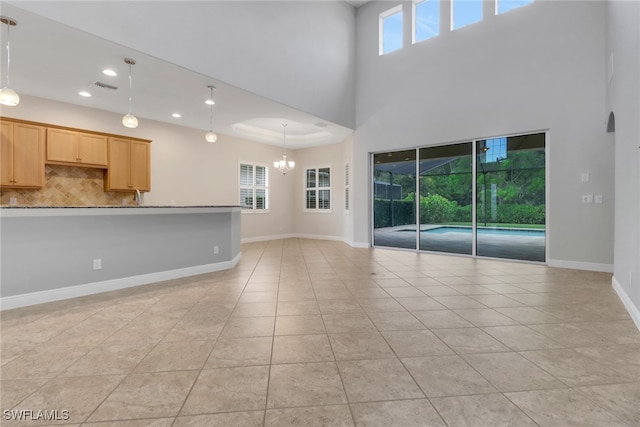 7787 Martino Cir, Naples, FL 34112 - unfurnished living room with light tile patterned flooring, plenty of natural light, recessed lighting, a chandelier, and a towering ceiling