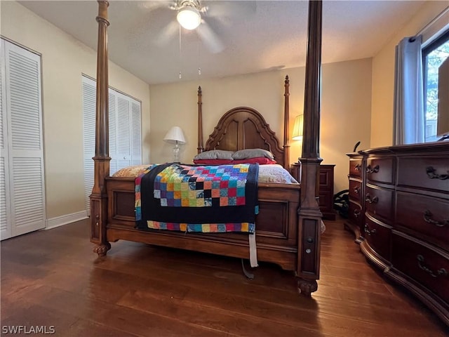 bedroom with wood-type flooring, a ceiling fan, two closets, and baseboards