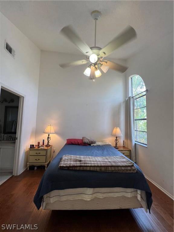 bedroom with dark hardwood / wood-style floors and ceiling fan