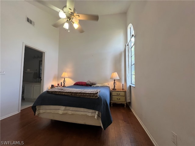 bedroom with ensuite bath, ceiling fan, and dark wood-type flooring