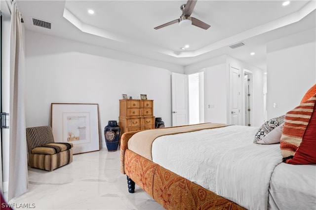 bedroom with a raised ceiling and ceiling fan