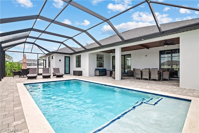 view of swimming pool with ceiling fan, a lanai, an outdoor living space, and a patio