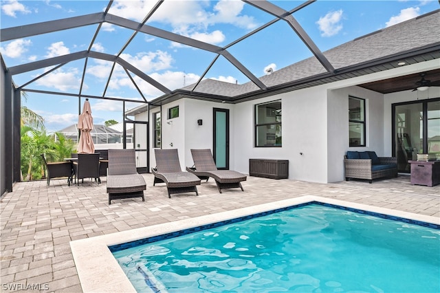 view of swimming pool featuring ceiling fan, a lanai, and a patio