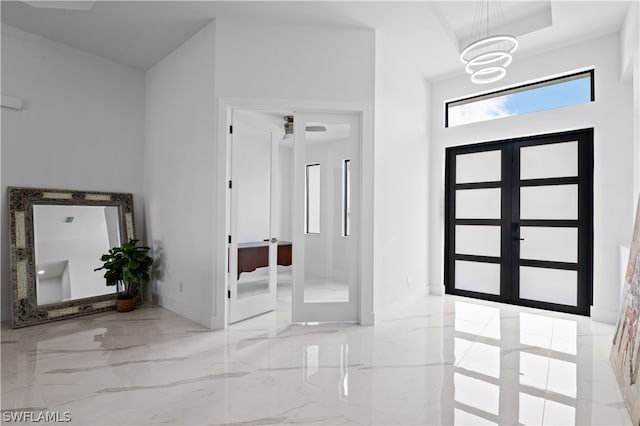 entrance foyer with a chandelier and french doors