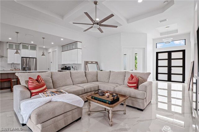 living room featuring beam ceiling, ceiling fan, sink, french doors, and coffered ceiling