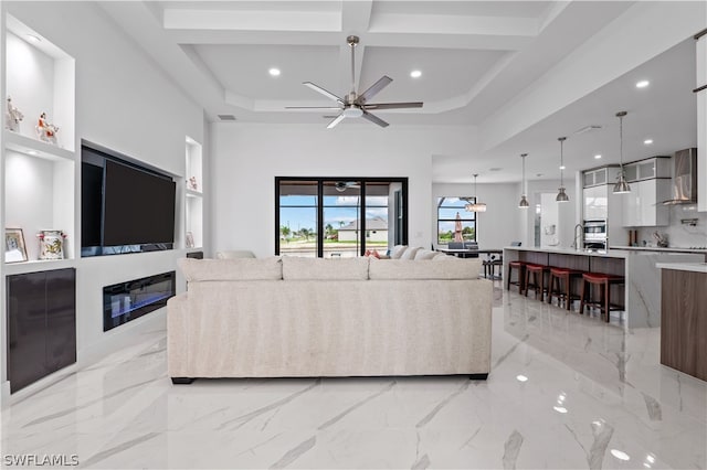 living room featuring ceiling fan and coffered ceiling