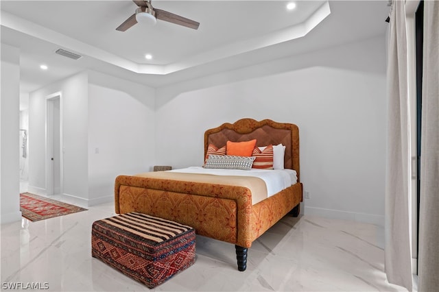 bedroom with ceiling fan and a raised ceiling